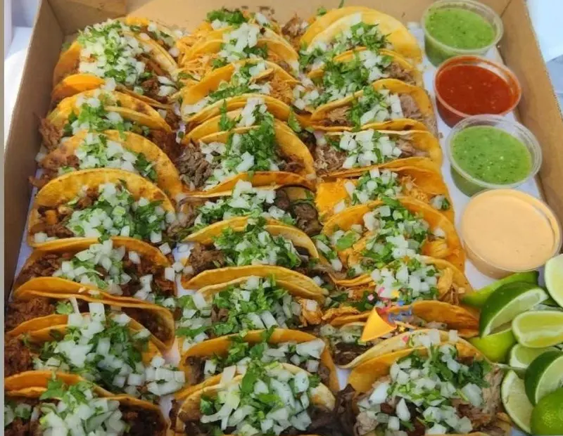 A box of 30 tacos with onion, cilantro, salsas and limes