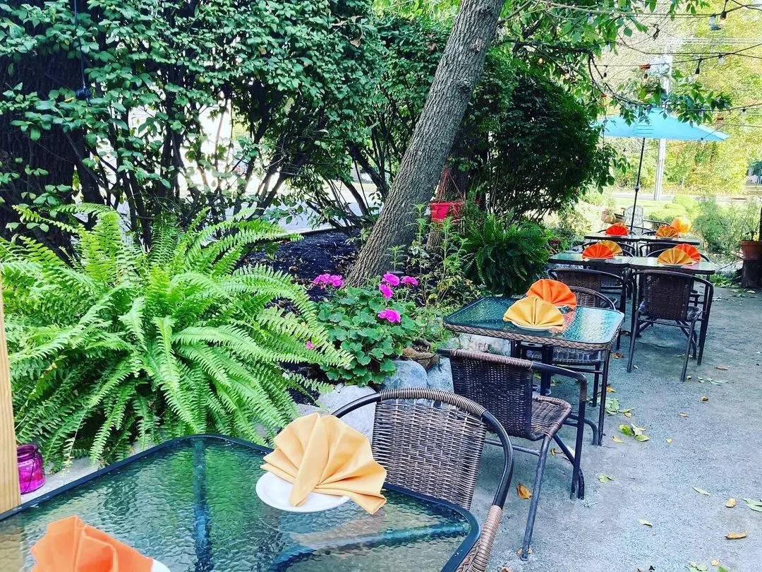 Ferns and flowers between patio tables with yellow napkins